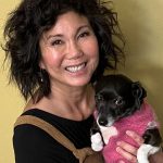 Dr._Tricia_Sera (1) Dr. Sera smiling holding a black and white dog